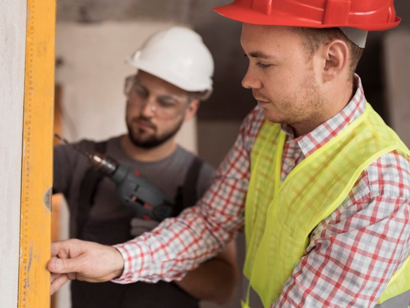 close-up-men-working-together-with-drill_23-2148751982