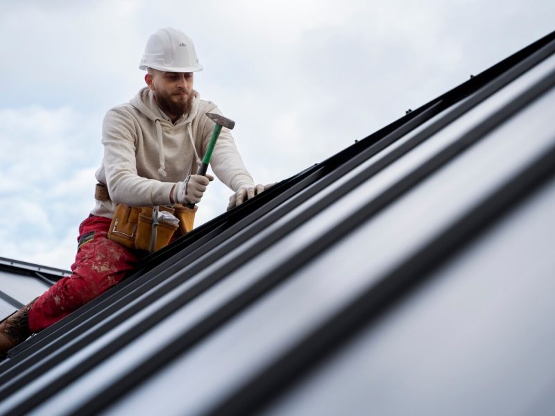 man-working-roof-with-hammer-full-shot_23-2149343668